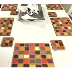 White tablecloth on dining table. Corkbacked funky placemats colourful Harlequin pattern.