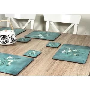 Wooden table with Infinity, teal blue background, corkbacked floral placemats and teapot
